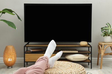 Woman having rest at stylish TV set, closeup