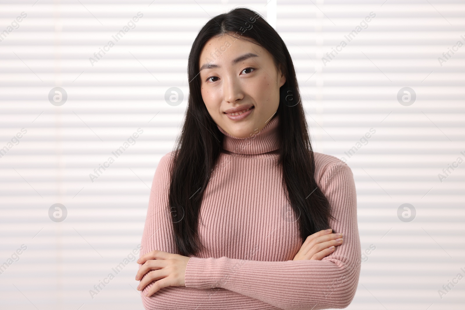 Photo of Portrait of smiling businesswoman with crossed arms in office