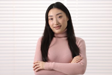 Photo of Portrait of smiling businesswoman with crossed arms in office