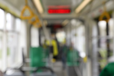 Photo of Blurred view of public transport interior with electronic display and handgrip handles