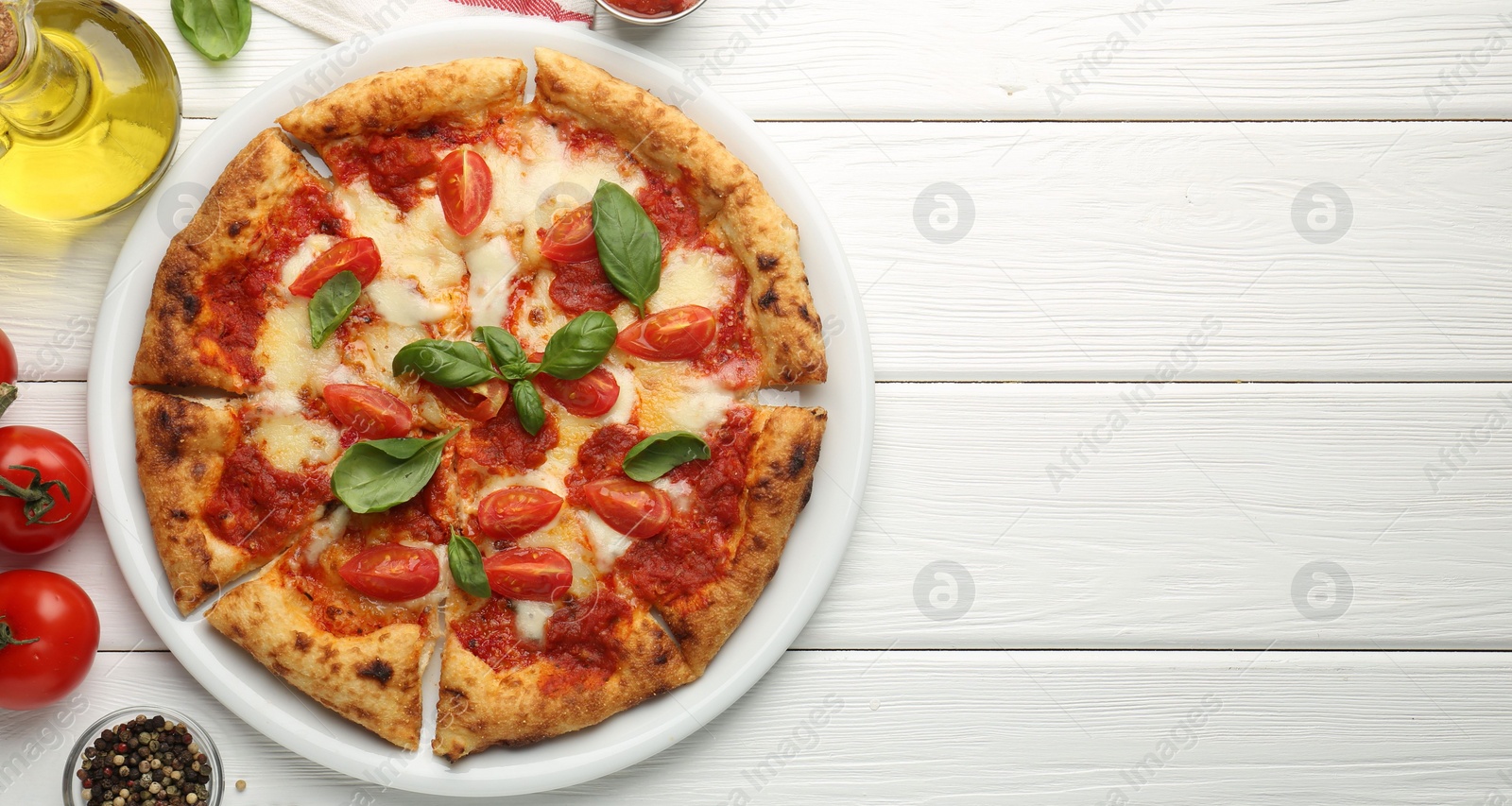 Photo of Delicious Margherita pizza and ingredients on white wooden table, top view. Space for text