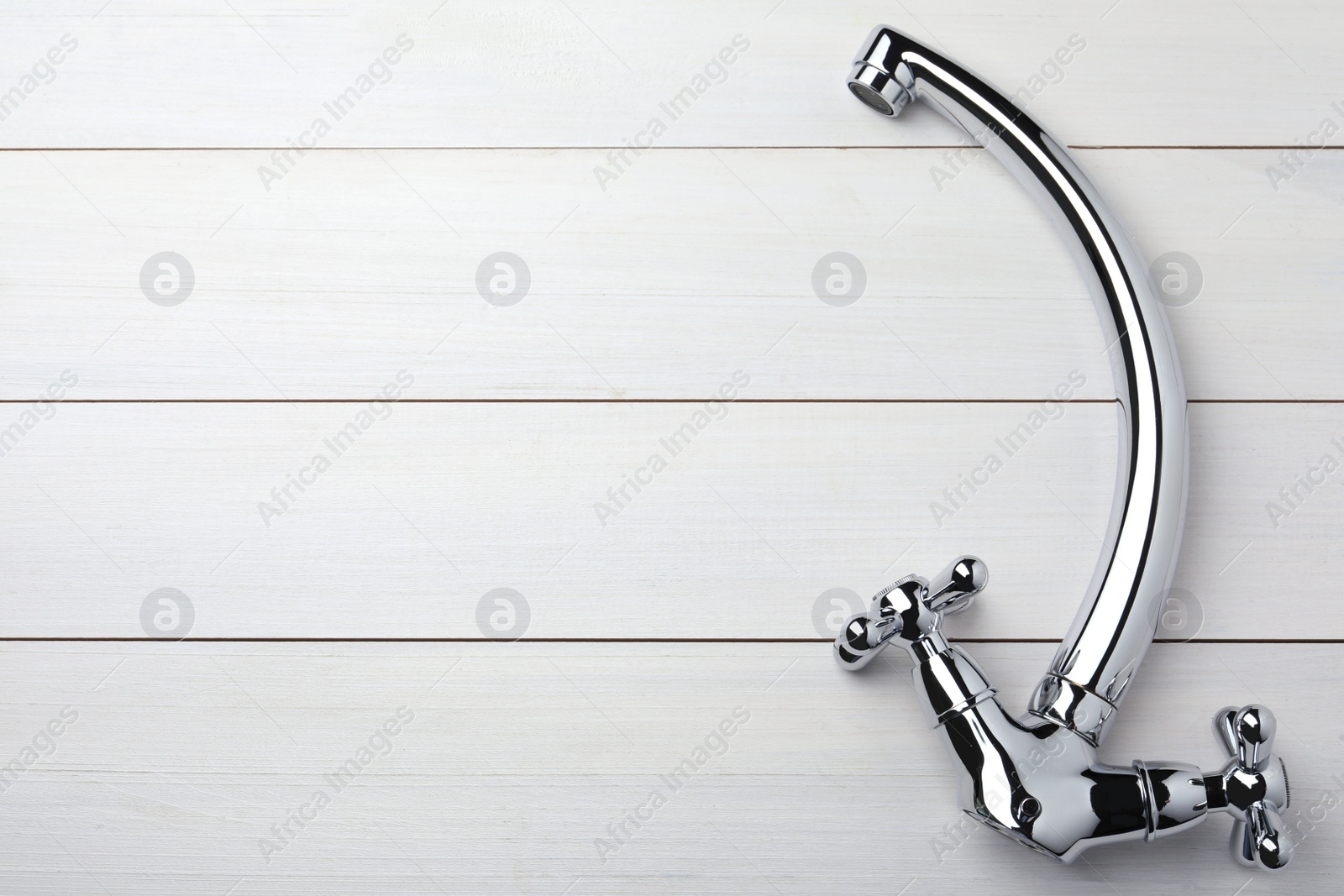 Photo of Double handle water tap on white wooden table, top view. Space for text