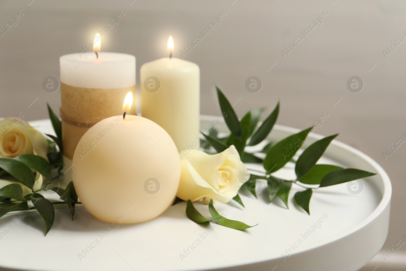Photo of Beautiful composition with burning candles and flowers on table