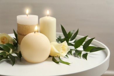 Beautiful composition with burning candles and flowers on table