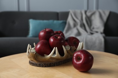 Photo of Red apples on wooden coffee table indoors