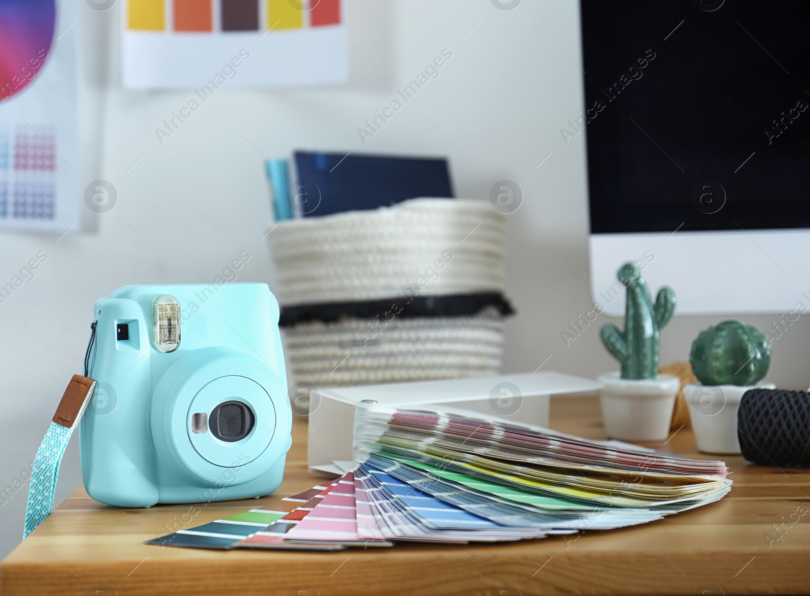 Photo of Digital camera and color palette on table in studio. Modern designer's workplace