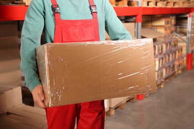 Photo of Worker with cardboard box in warehouse, closeup. Wholesaling