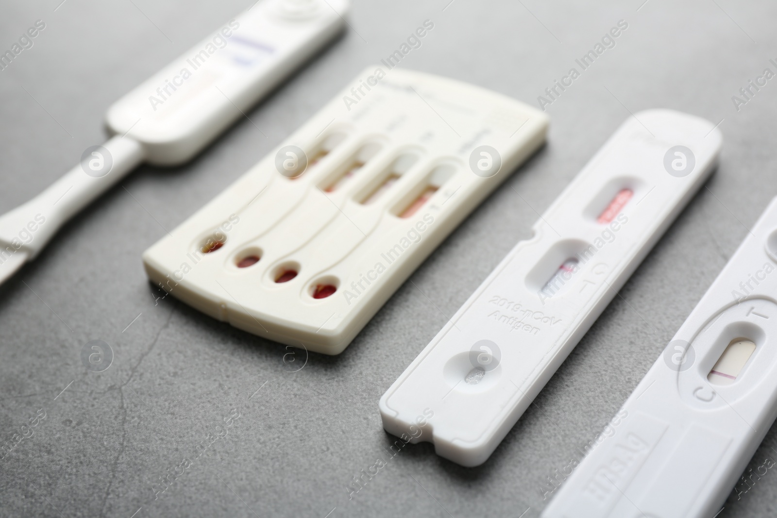 Photo of Different disposable express tests on grey table, closeup