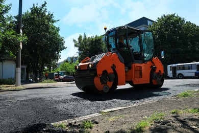 Photo of Roller working on city street. Road repairing