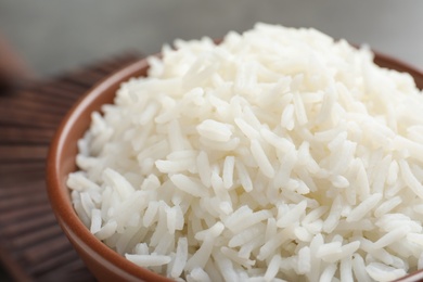 Photo of Bowl of tasty cooked white rice on table, closeup