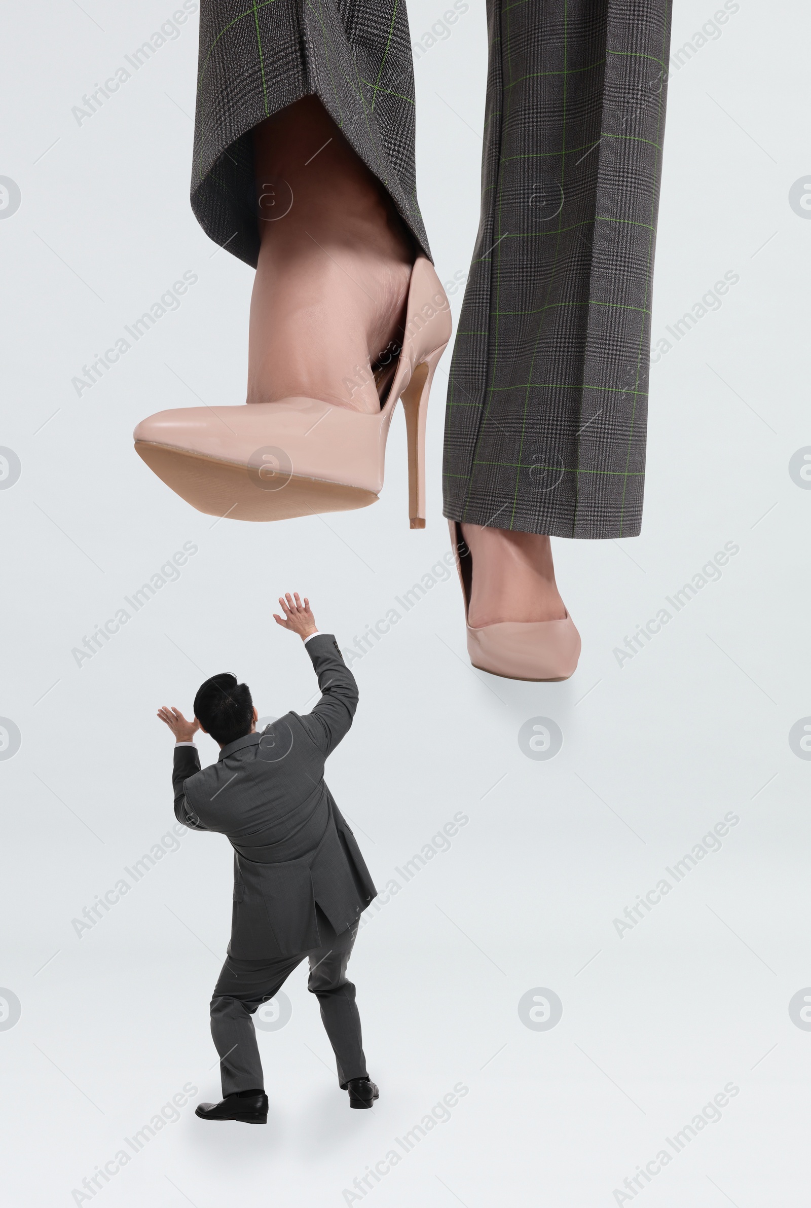 Image of Big woman stepping onto small man on white background