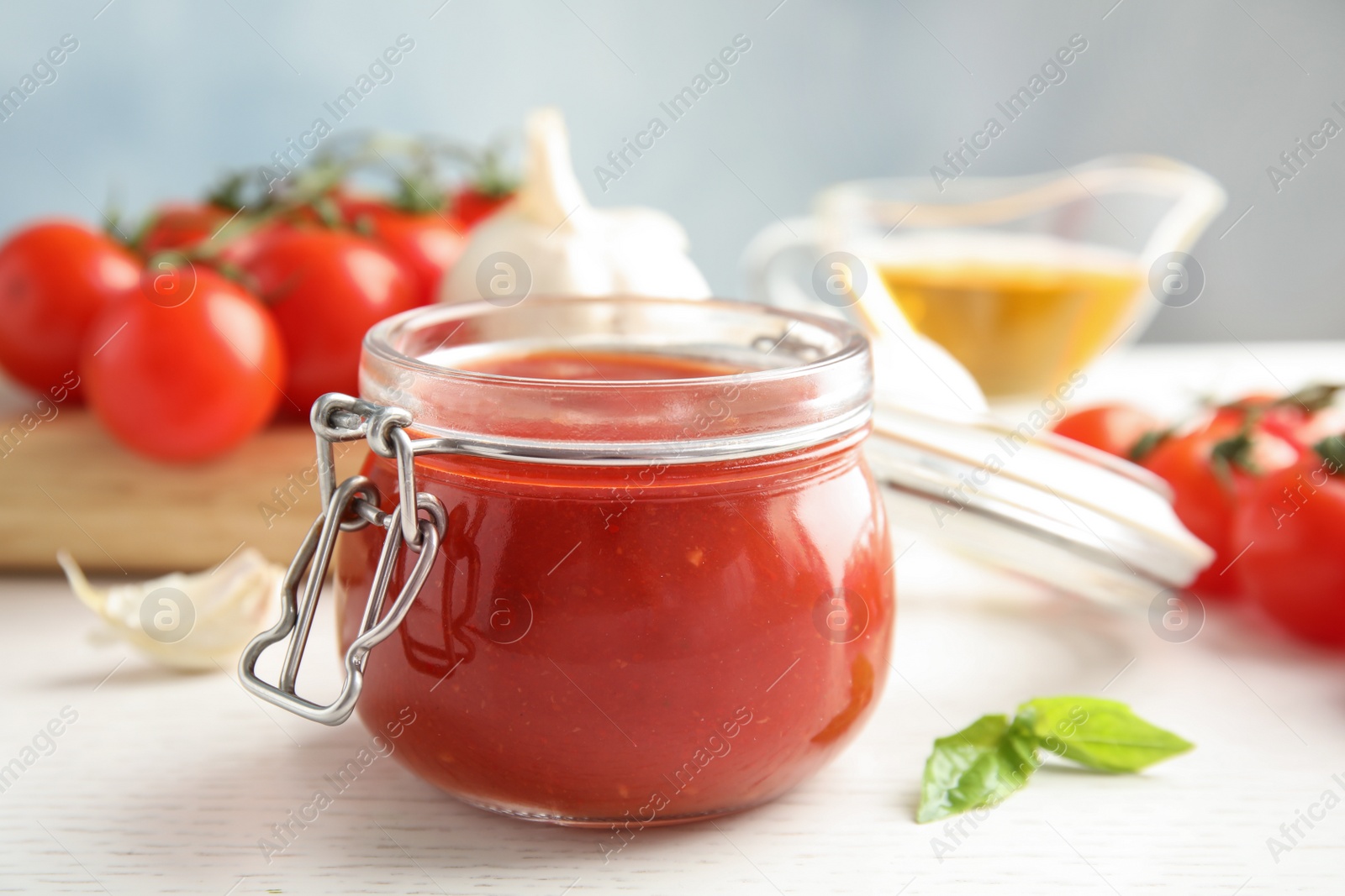 Photo of Jar of tasty tomato sauce on wooden table, closeup