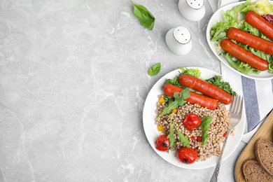 Tasty buckwheat porridge with sausages, flat lay. Space for text