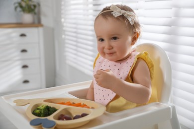 Cute little baby wearing bib while eating at home