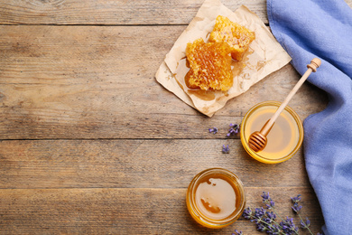 Flat lay composition with tasty honey on wooden table. Space for text