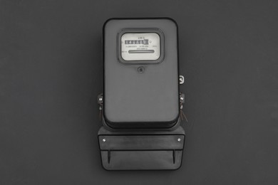 Electric meter on black background, top view. Measuring device