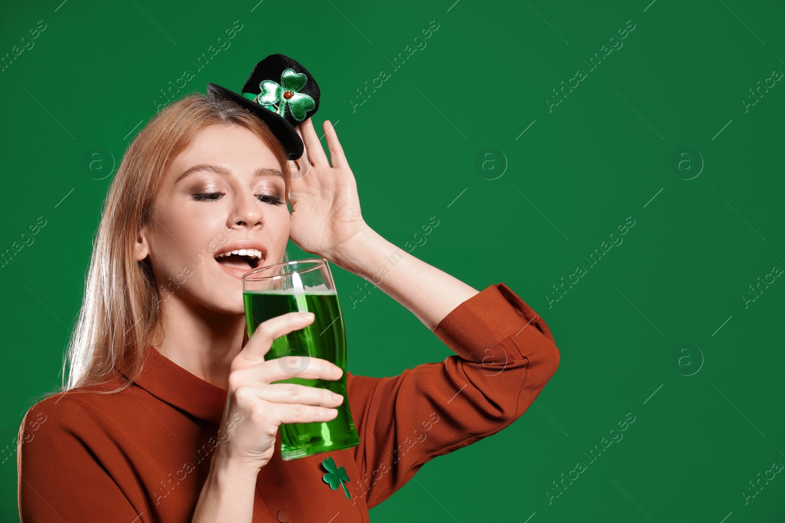 Photo of Young woman with green beer on color background. St. Patrick's Day celebration