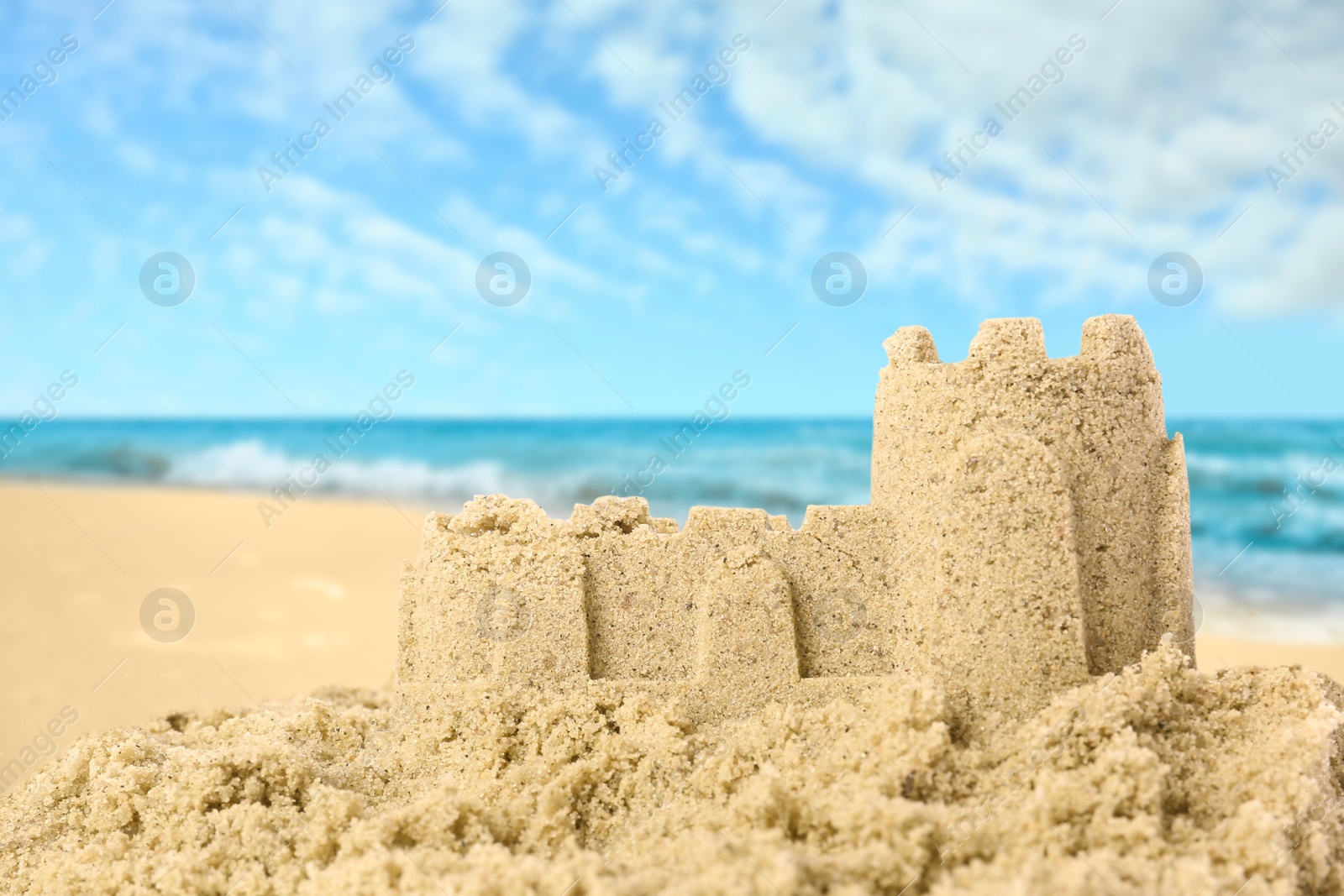 Image of Sand castle on ocean beach, closeup with space for text. Outdoor play