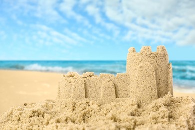 Sand castle on ocean beach, closeup with space for text. Outdoor play