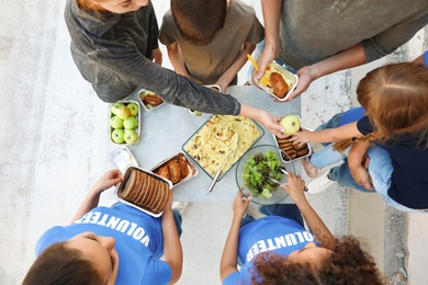 Photo of Volunteers serving food to poor people outdoors, top view