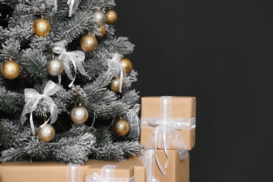 Photo of Decorated Christmas tree and gift boxes against black background