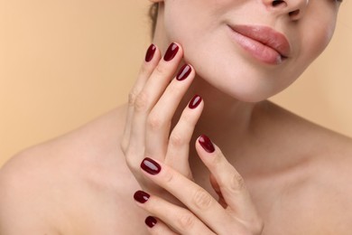 Woman with beautiful lips on beige background, closeup