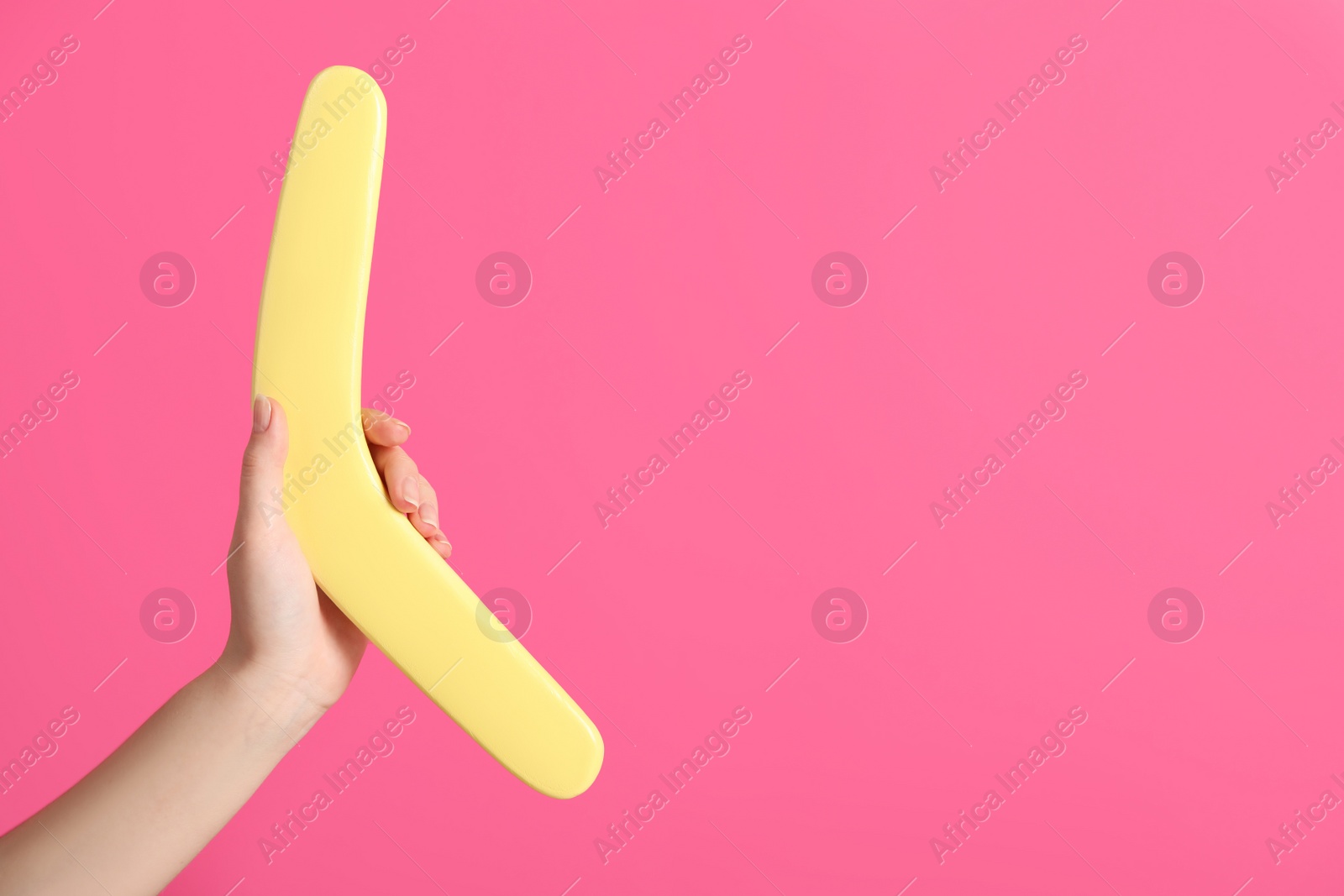 Photo of Woman holding boomerang on pink background, closeup. Space for text
