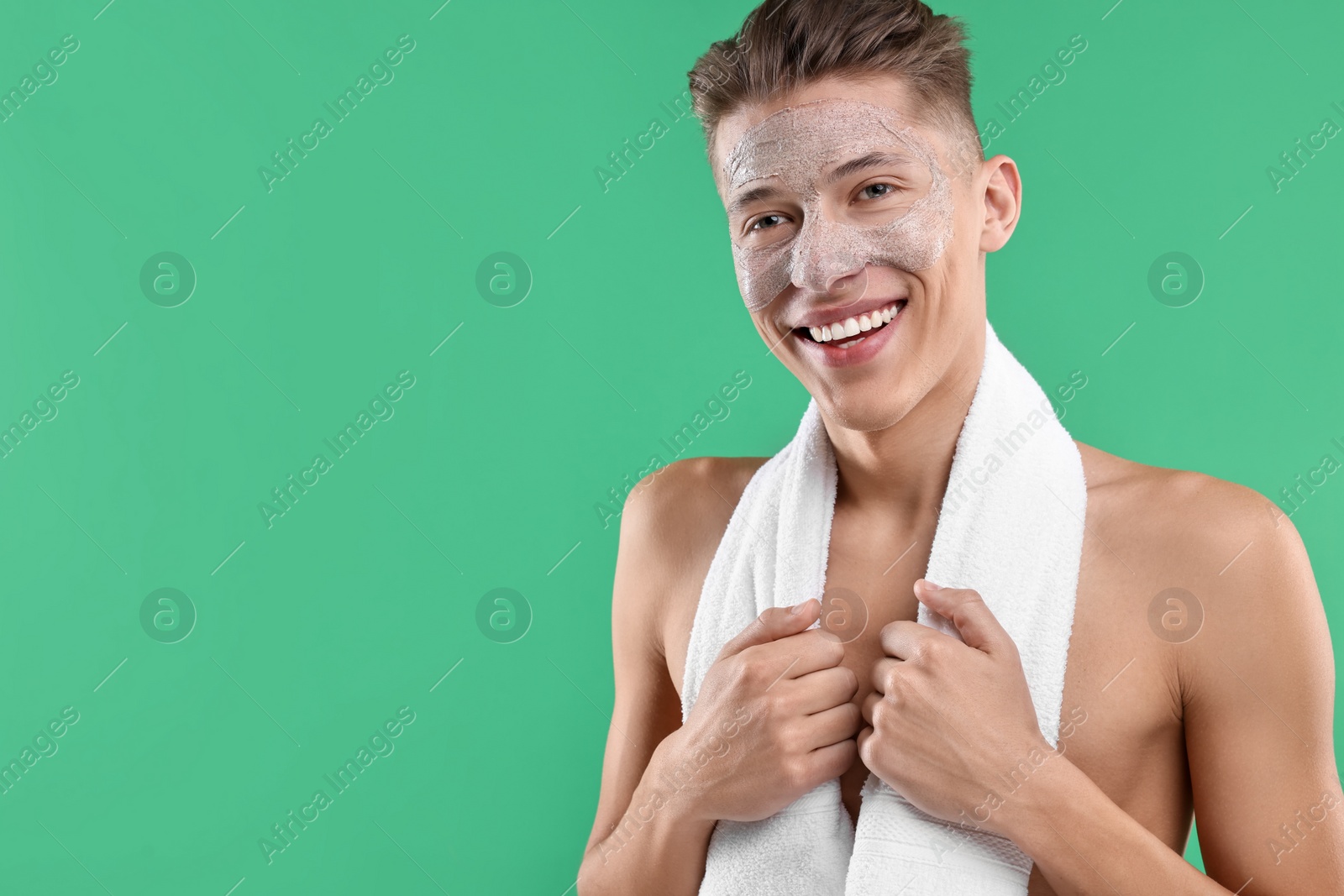 Photo of Handsome man with facial mask on his face against green background. Space for text