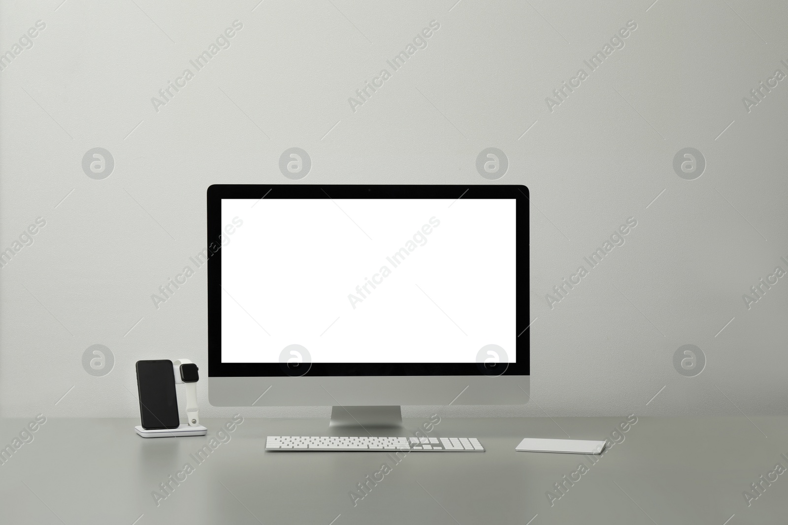 Photo of Modern workplace with computer and charging devices. Interior design