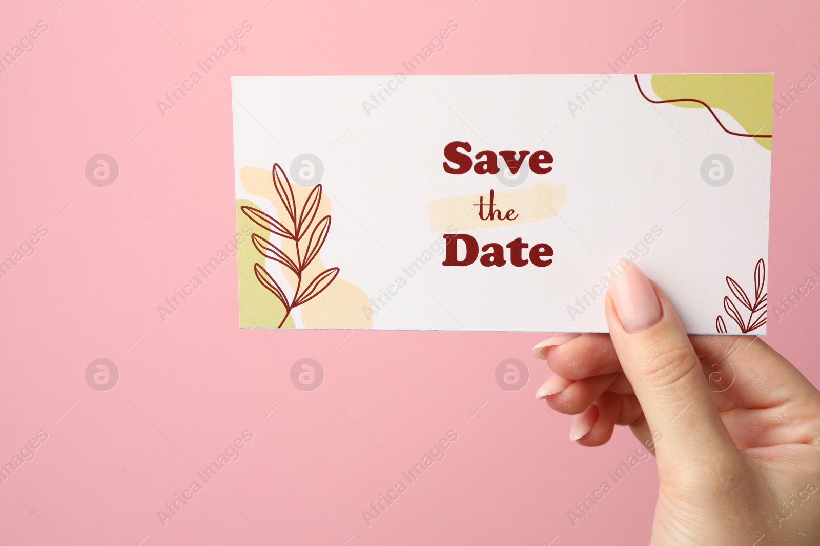 Photo of Woman holding beautiful card with Save the Date phrase on pink background, closeup