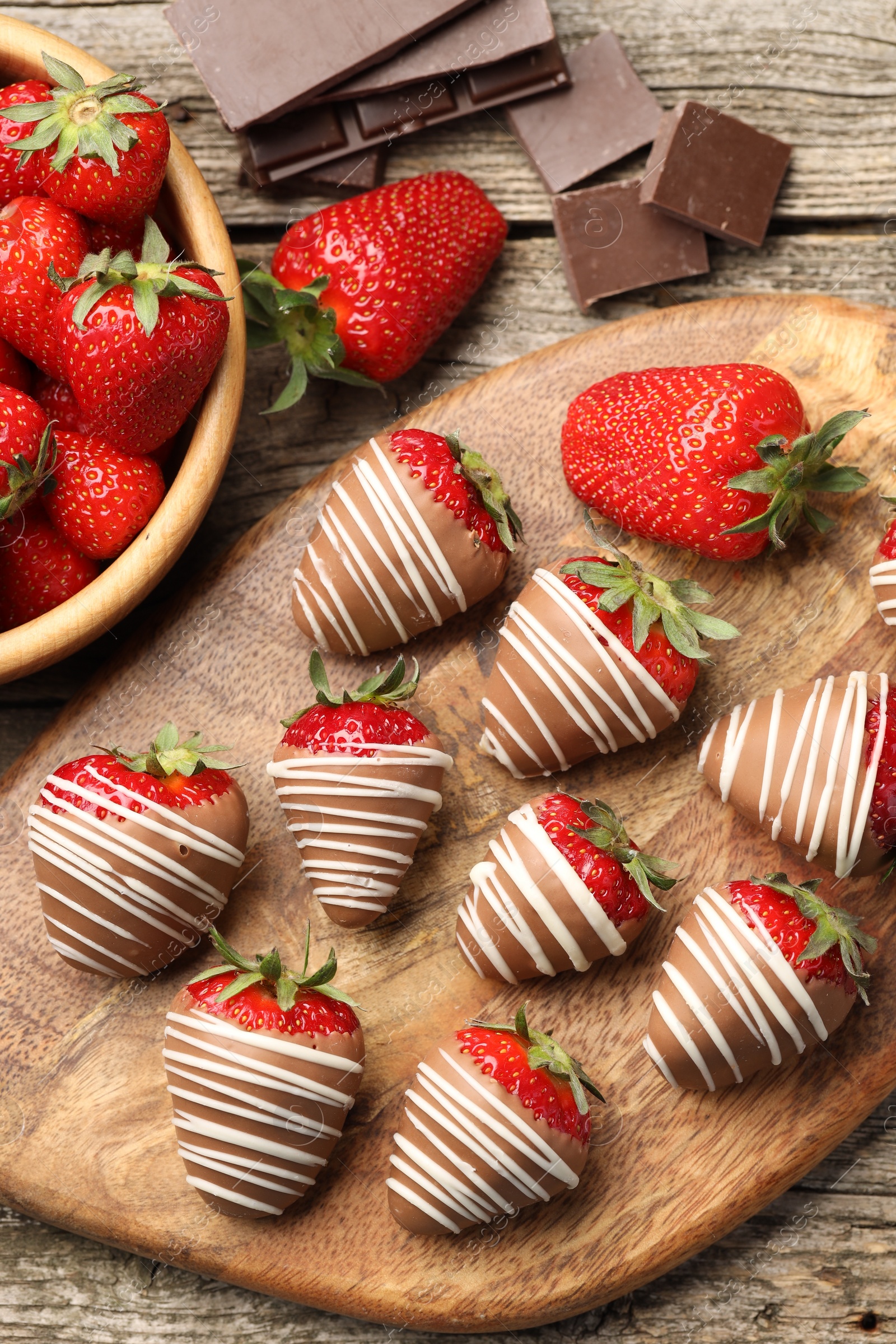 Photo of Delicious chocolate covered strawberries on wooden table, flat lay