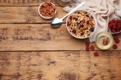 Tasty granola served with nuts and dry fruits on wooden table, flat lay. Space for text