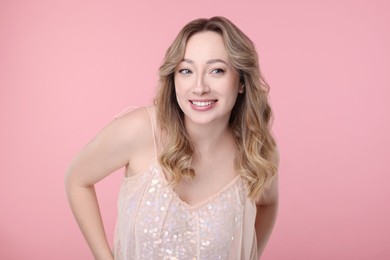 Photo of Portrait of smiling woman on pink background