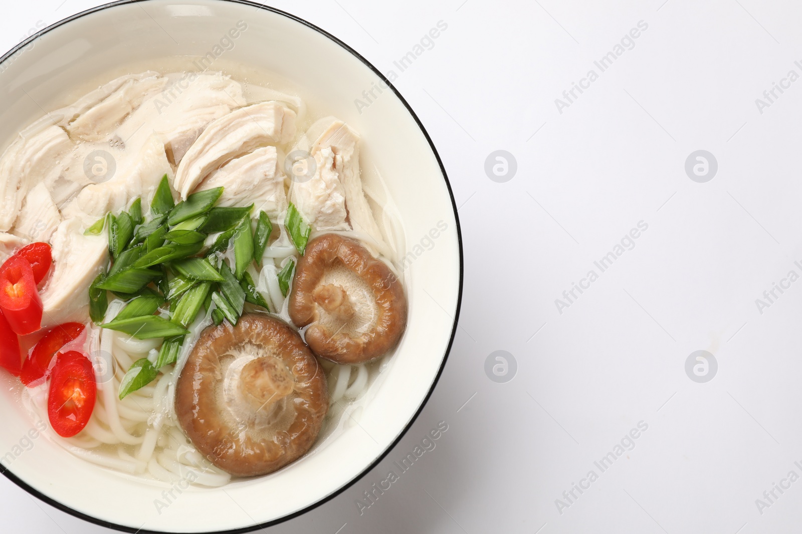 Photo of Delicious ramen with meat and mushrooms in bowl on white background, top view. Space for text