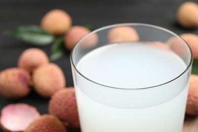 Photo of Glass of fresh lychee juice on table, closeup