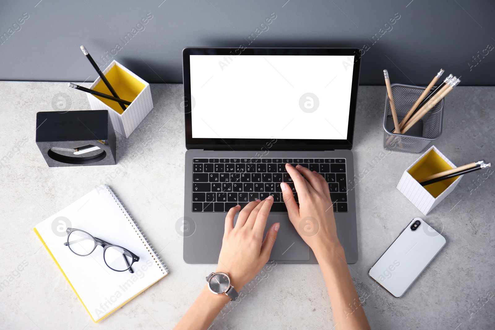 Photo of Female blogger using laptop at table, top view. Blank screen for mockup