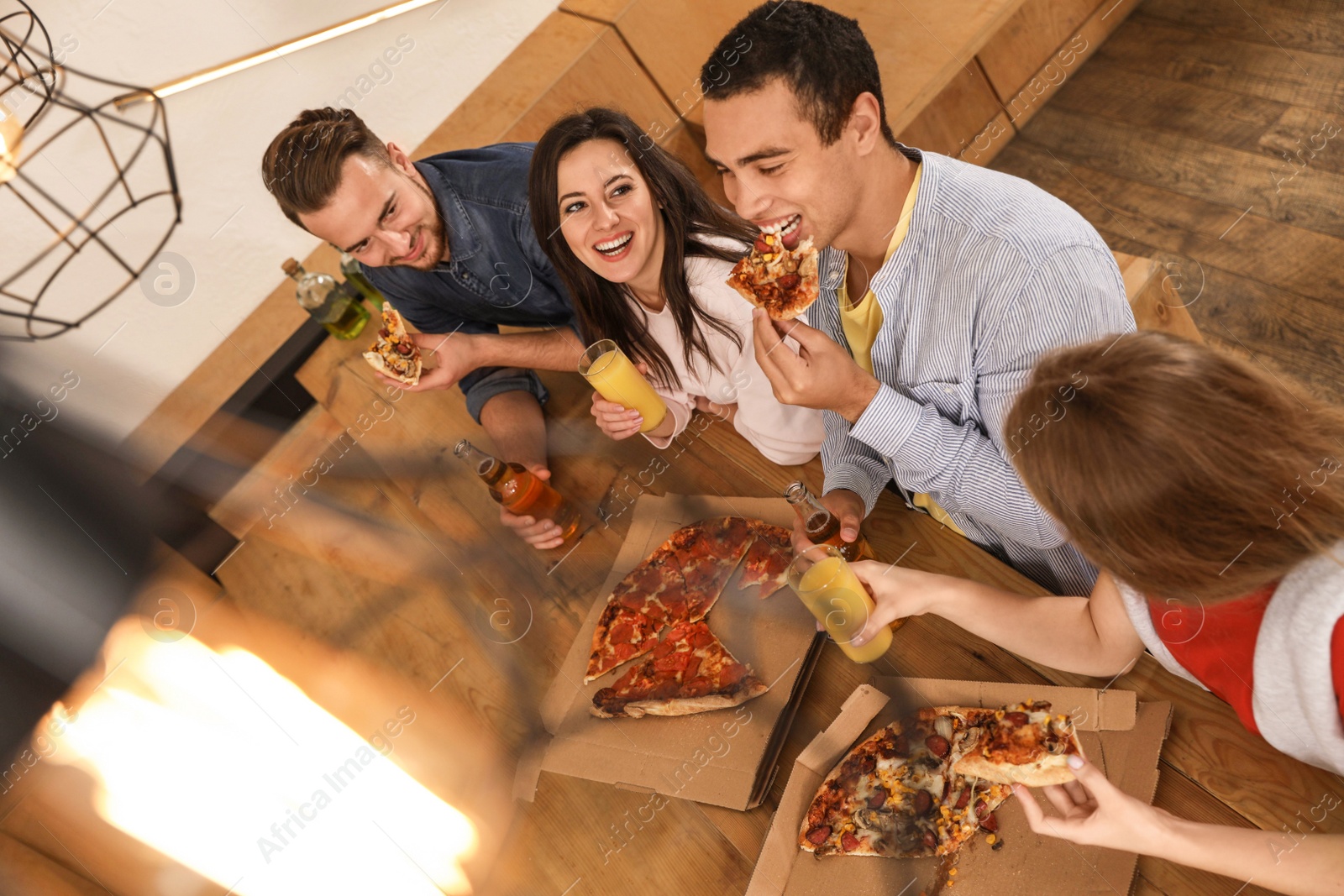 Photo of Group of friends having fun party with delicious pizza in cafe