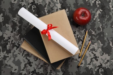 Photo of Flat lay composition with books and diploma on camouflage background. Military education concept