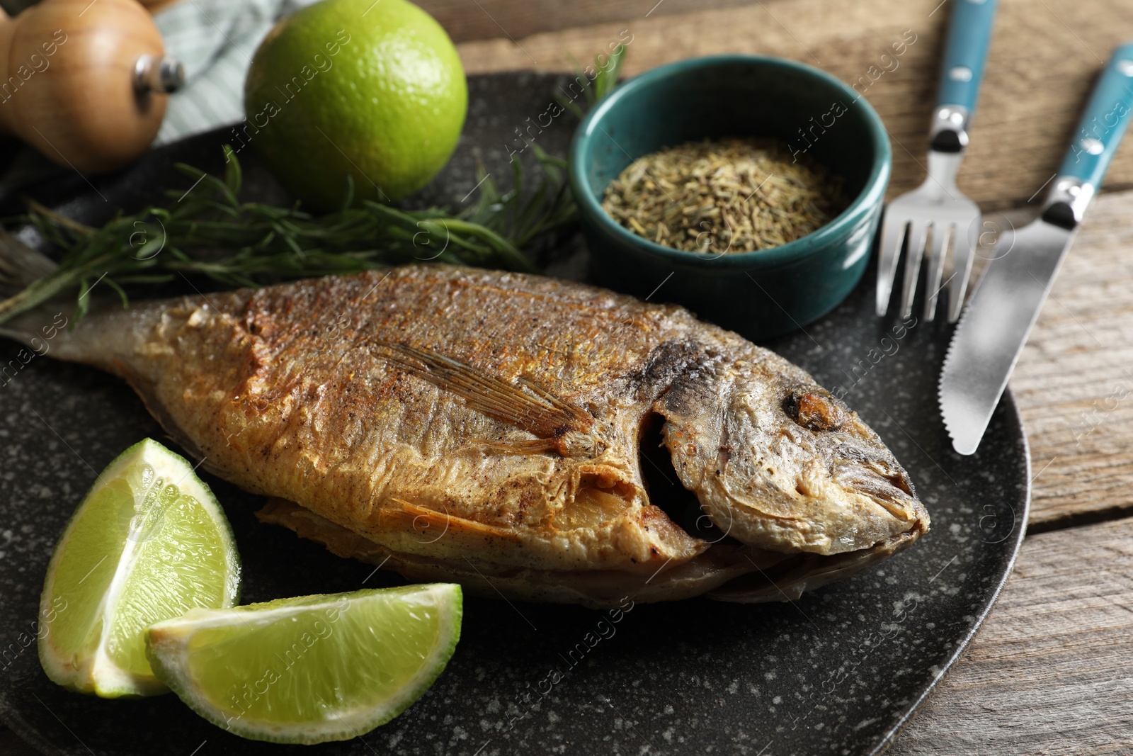 Photo of Delicious dorado fish served on wooden table, closeup