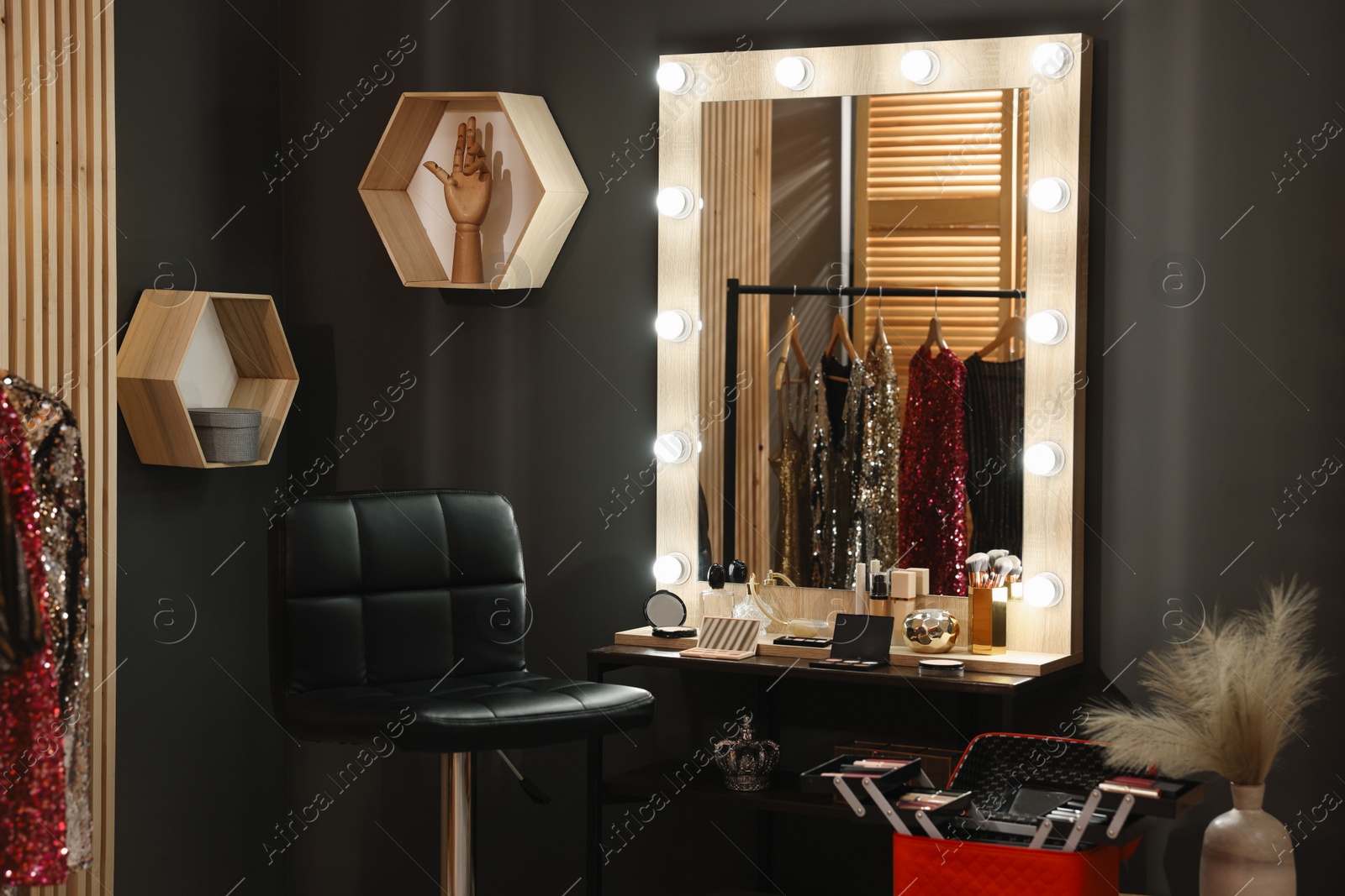 Photo of Makeup room. Stylish mirror near dressing table with beauty products and chair indoors