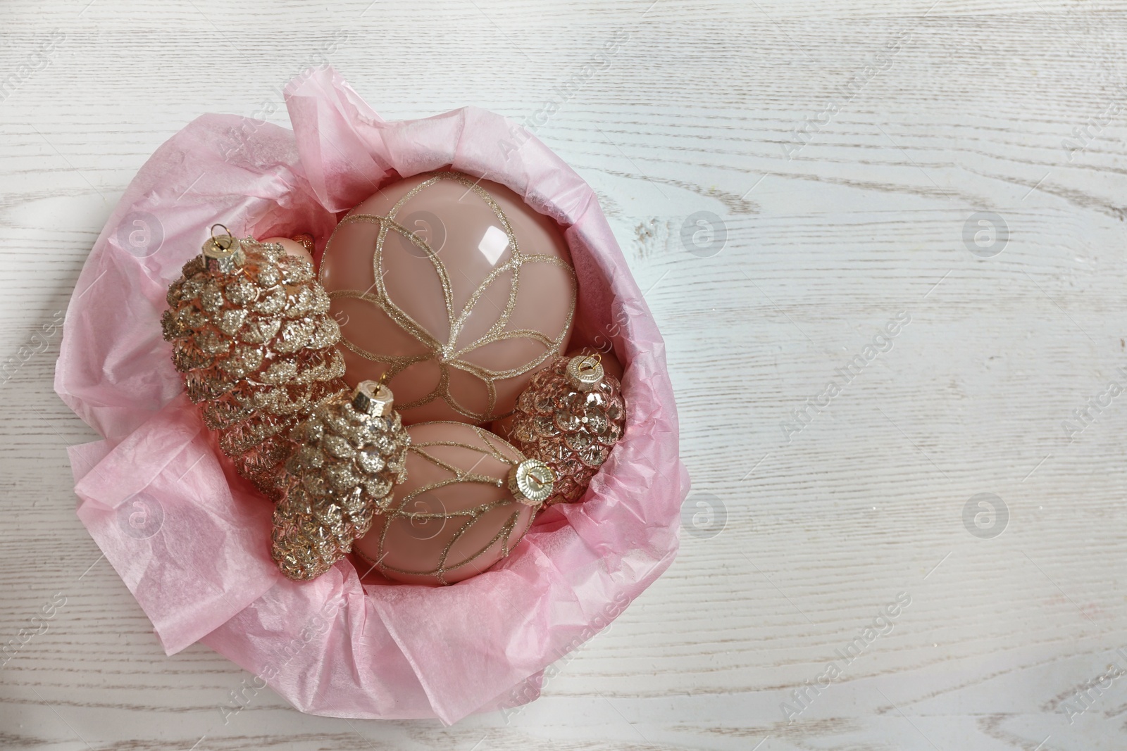 Photo of Collection of beautiful Christmas tree baubles on white wooden table, top view. Space for text