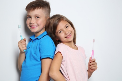 Portrait of cute children with toothbrushes on white background