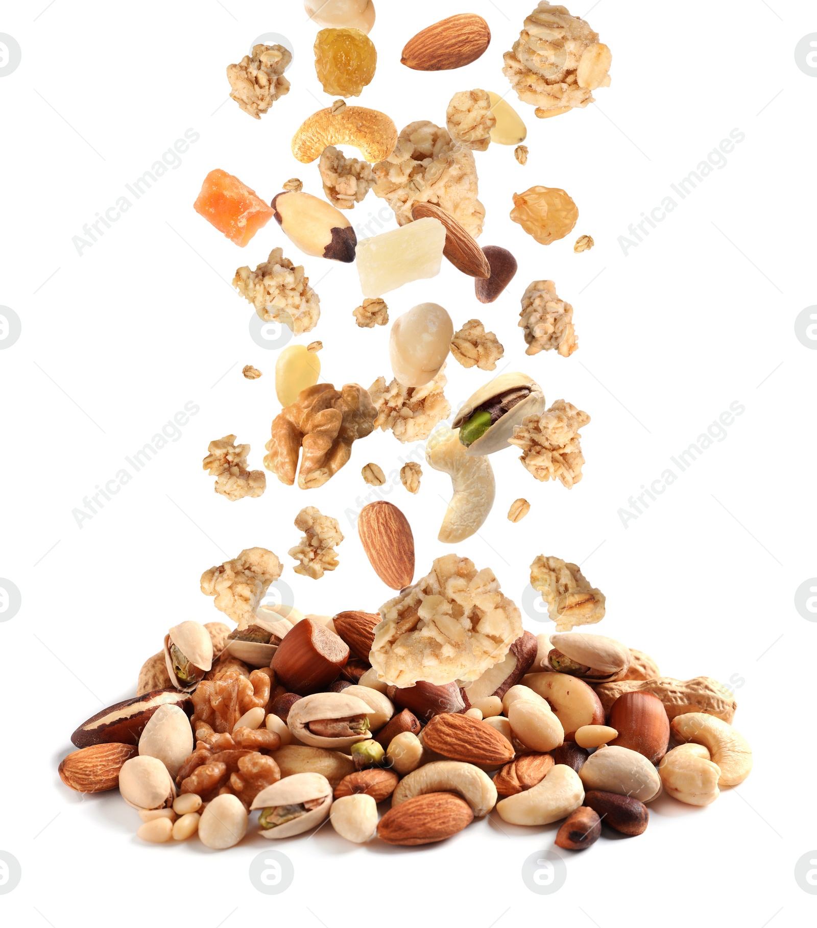 Image of Delicious granola, nuts and dried fruits falling into pile on white background. Healthy snack 