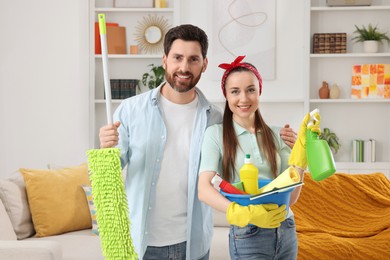 Photo of Spring cleaning. Couple with detergents and mop in living room