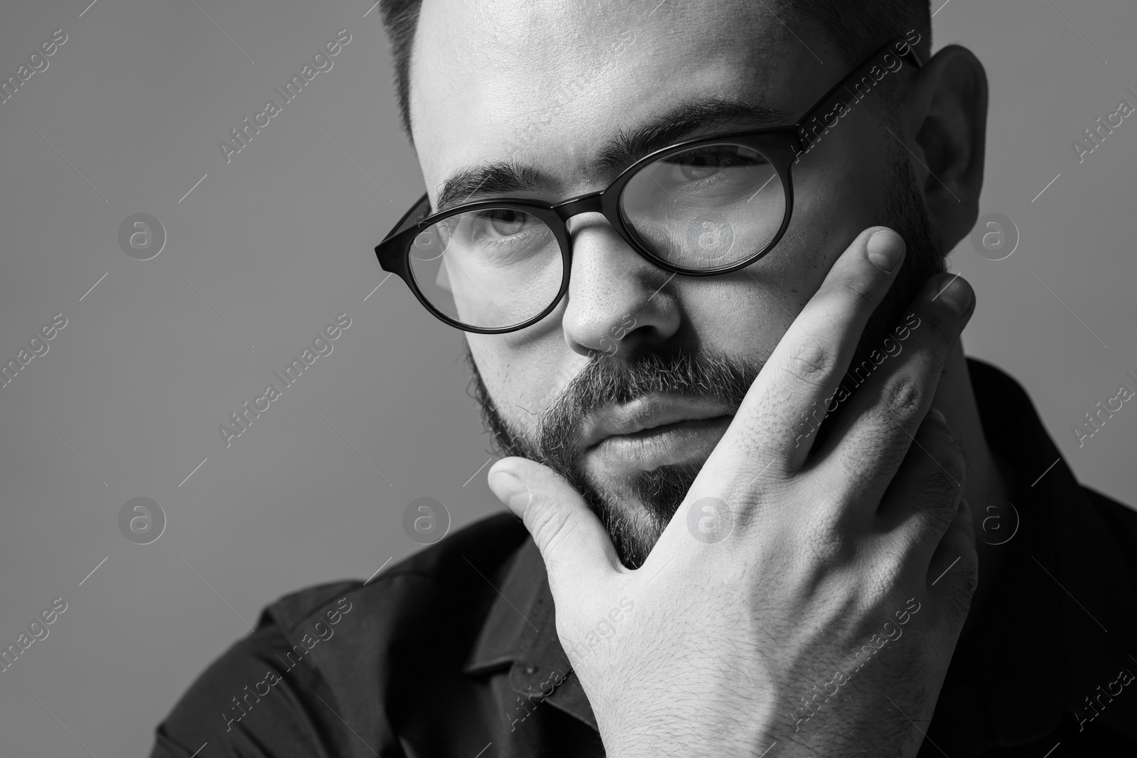 Photo of Portrait of handsome bearded man on grey background. Black and white effect