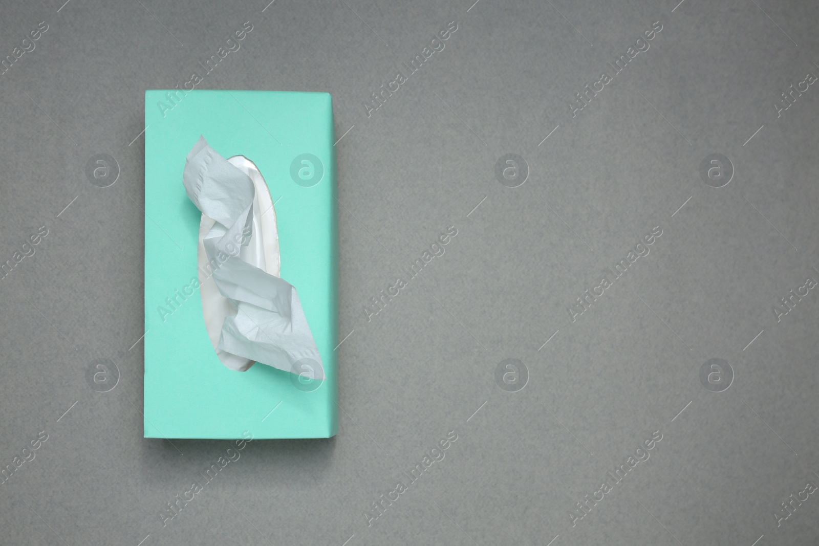 Photo of Box of paper tissues on grey background, top view. Space for text