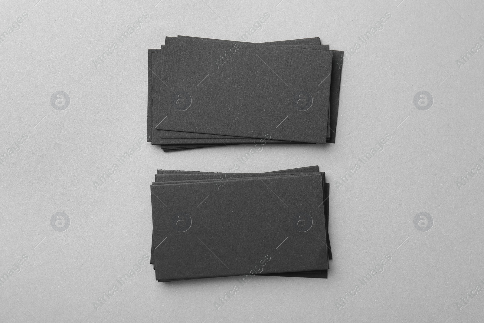 Photo of Blank black business cards on light background, top view. Mockup for design