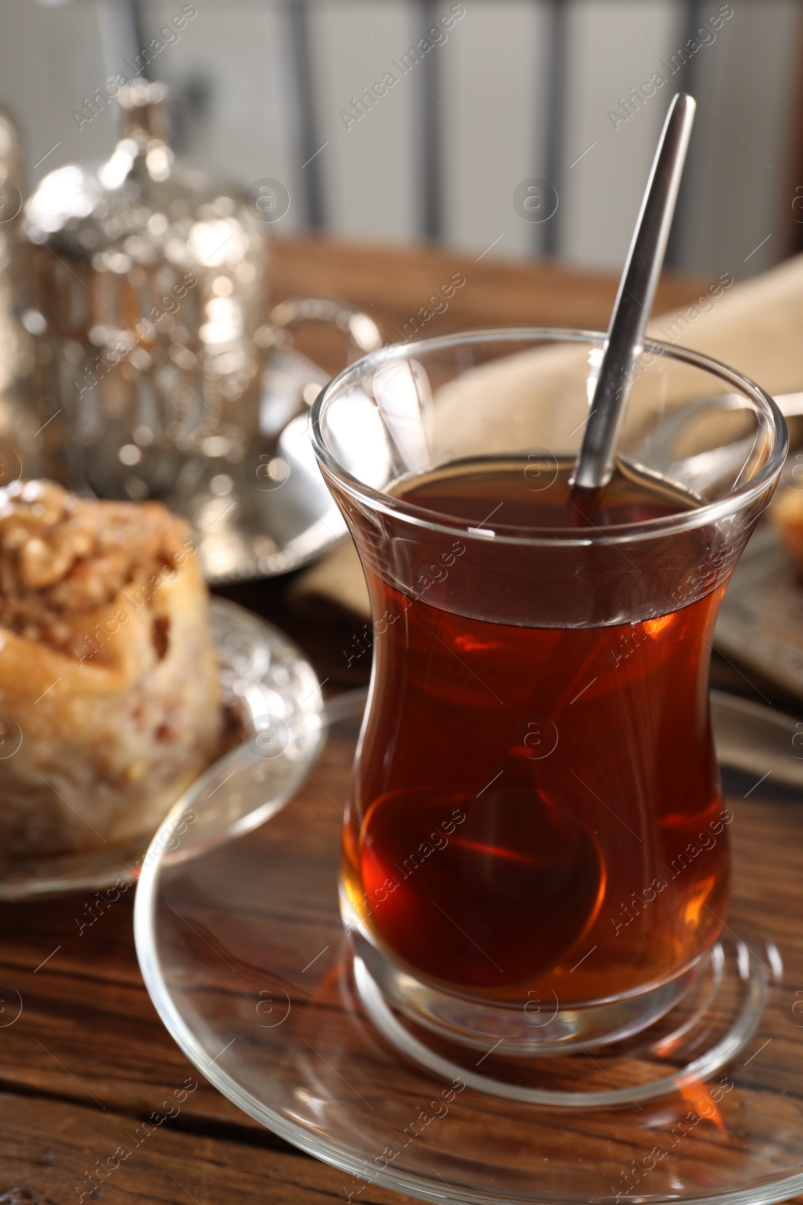 Photo of Traditional Turkish tea in glass on wooden table, closeup