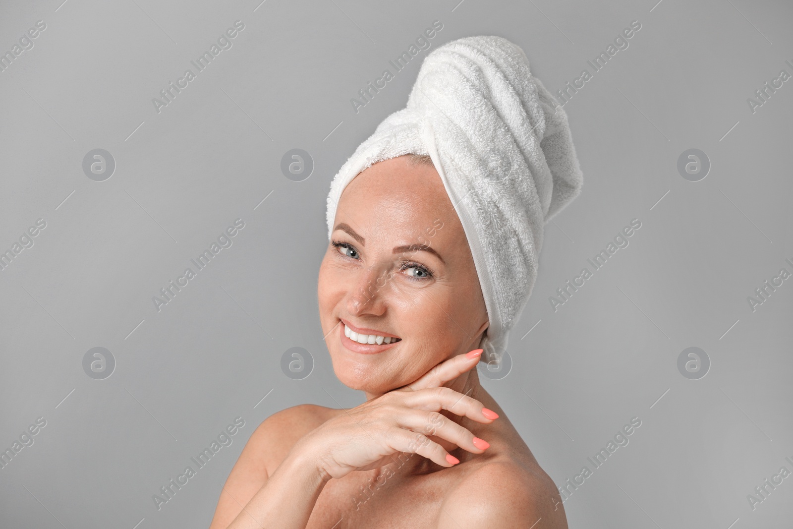 Photo of Portrait of beautiful mature woman with perfect skin on grey background