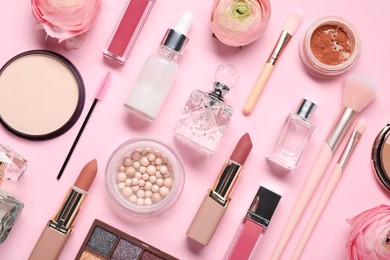 Photo of Flat lay composition with different makeup products and beautiful spring flowers on pink background